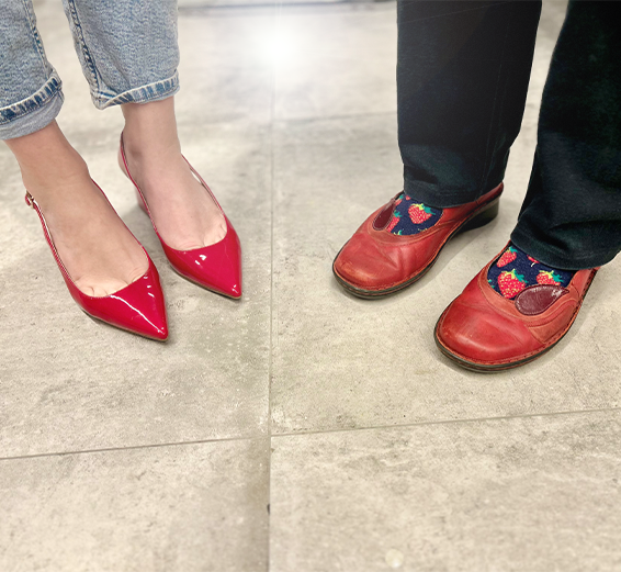 Two pairs of red shoes standing on a tiled surface